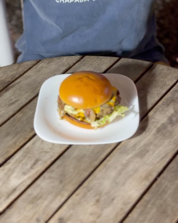 Hambúrguer no prato sobre a mesa de madeira